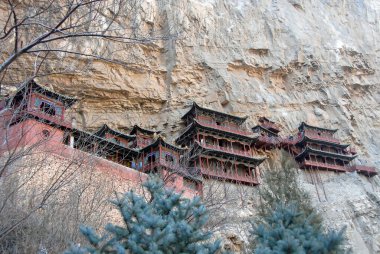 The Hanging Temple or Hanging Monastery near Datong in Shanxi Province, China. View of the Hanging Temple with trees in the foreground. The temple is a major tourist sight near Datong. clipart