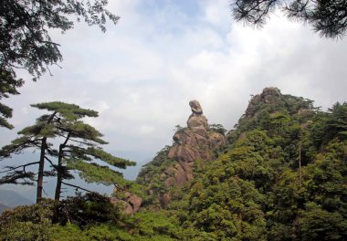 Sanqingshan Dağı, Jiangxi Eyaleti, Çin. Tanrıça Tepesi manzarası, Sanqing Dağı 'nda kayalık bir çıkıntı. Uzağa bakan bir kadını temsil ediyor. Sanqingshan yemyeşil ormanları olan bir Taoist dağıdır.