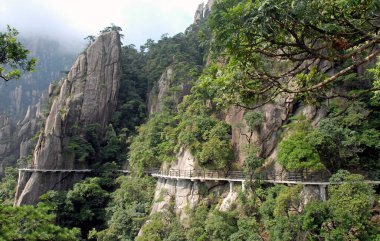 Sanqingshan Dağı, Jiangxi Eyaleti, Çin. Sanqing Dağı 'ndaki uçuruma tutunan bir patika. Sanqingshan, sisli tepeleri ve yemyeşil ormanlarıyla ünlü kutsal bir Taoist dağıdır..
