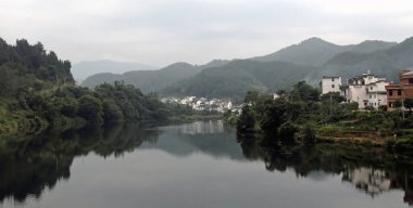 Wuyuan County 'deki Wangkou, Jiangxi Eyaleti, Çin. Wangkou, Tang Hanedanlığı mimarisi ile tanınan Wuyuan ilinde antik bir kasabadır. Nehir ve tepeli geleneksel beyaz evler.