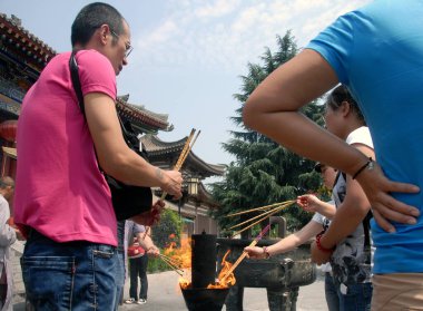 Famen Tapınağı, Famen Town, Shaanxi Eyaleti, Çin: Eski Famen Tapınağı 'nda ibadet edenler tütsü yakıyor. Tarihi tapınakta tütsü taşıyan ziyaretçiler var..