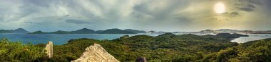 Panoramic view from whale island to the sea with fishing villages on the water and the mainland.  The sun shines through the clouds. Vietnam.