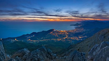 The view from the mountain rumija at sunset. Evening lights of the Bar city. Mediterranean Sea, Montenegro