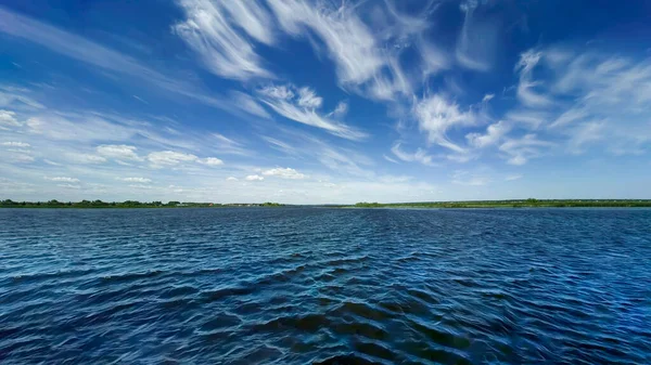 Błękitne Niebo Białymi Chmurami Cyrru Turkusowa Woda Zielone Wybrzeże Horyzoncie — Zdjęcie stockowe