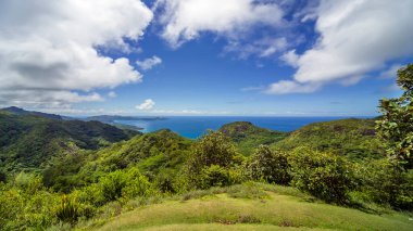 Panoramic view of the sea and the islands of Batangas province. The mountains are covered with green tropical plants. Blue sky with white clouds. Mindoro Island, Philippines.