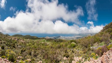 Rumia Dağı 'nın tepesinden bak. Mavi gökyüzü bulutlarla birleşiyor ufuktaki denizle. Karadağ.