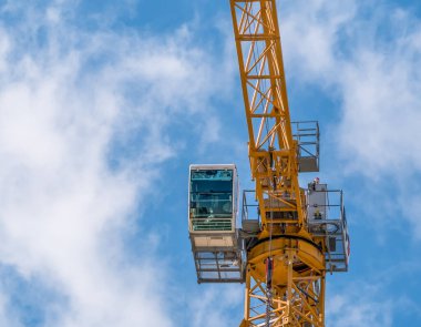 Ayrıntıları bir inşaat vincinin kabin kontrolüyle kapat. Turnayı mavi gökyüzüne doğru döndüren kule.