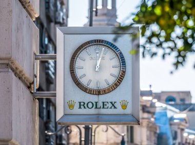 Bükreş / Romanya - 10.17.2020: Bükreş 'teki eski bir binada Rolex açık hava saati. Rolex SA, Cenevre merkezli İsviçreli lüks saat üreticisi.