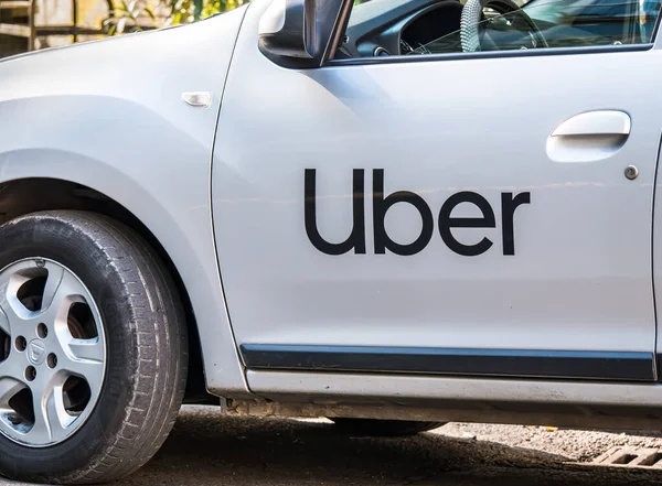 Bükreş / Romanya - 10.17.2020: Beyaz boyalı bir arabada Uber logosu yazılı. Trafikte Uber araba.