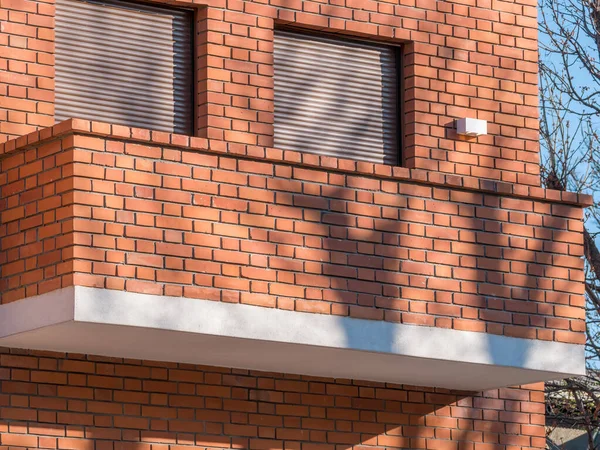 Detail with a modern minimalist architecture. Balcony made of red bricks.