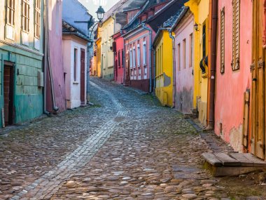 Romanya 'da kaldırım taşı sokakları ve Sighisoara Ortaçağ Kalesi' nin eski binalarıyla renkli bir manzara.