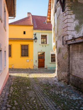 Romanya 'da kaldırım taşı sokakları ve Sighisoara Ortaçağ Kalesi' nin eski binalarıyla renkli bir manzara.