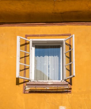 Romanya 'nın Sighisoara kentindeki turuncu bir duvardaki açık pencerenin ayrıntıları.