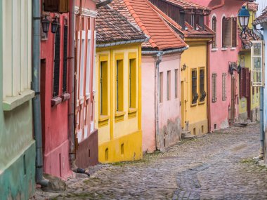 Romanya 'da kaldırım taşı sokakları ve Sighisoara Ortaçağ Kalesi' nin eski binalarıyla renkli bir manzara.