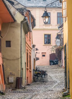 Sighisoara Romanya - 11,26,2020: Romanya 'da kaldırım taşı sokakları ve Sighisoara Ortaçağ Kalesi' nin eski binaları ile sahne.