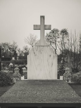 Mezarlıkta beyaz mermer haç.