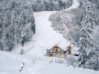 Garbova dağ kulübesi karla kaplı kış manzarası. Romanya 'daki Karpat Dağları' nın bir kısmı Baiului Dağları 'nda.