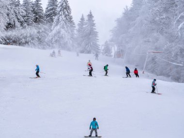 Ön anlaşma, Romanya - 01.13.2021: Romanya 'daki Predeal Mountain tatil beldesinde kayak yapan insanlar