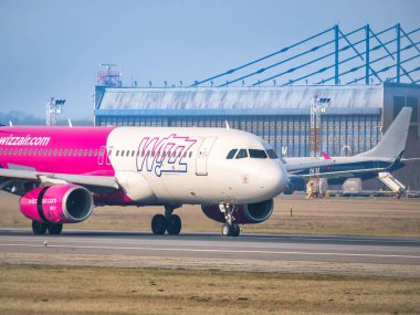 Otopeni, Romanya - 01.23.2021: Henri Coanda Uluslararası Havalimanı 'ndaki havaalanı pistinde bir Wizz Air Airbus A320-232 (HA-LWN) uçağı.