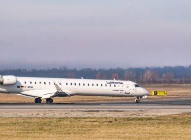 Otopeni, Romanya - 01.23.2021: Henri Coanda Uluslararası Havalimanı havaalanı pistinde bir Lufthansa Mitsubishi CRJ-900LR uçağı.