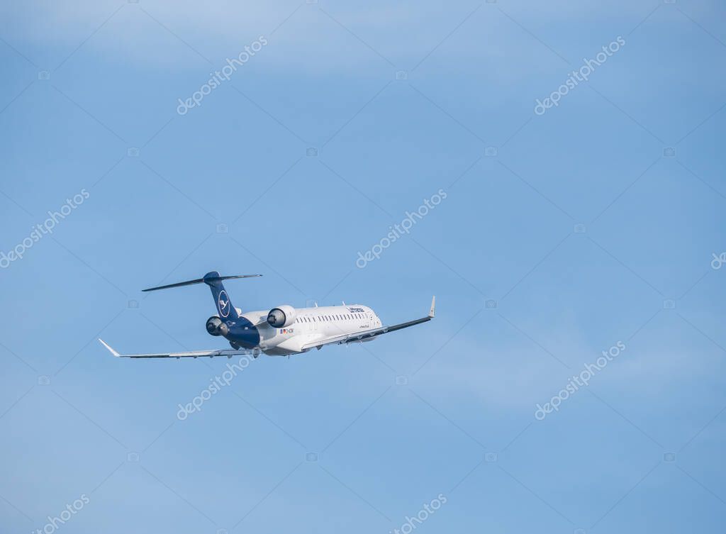 Otopeni, Romania - 01.23.2021: A Lufthansa Mitsubishi CRJ-900LR (D-ACNK) airplane flying against blue sky