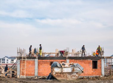 Bükreş, Romanya - 01.23.2021: Bükreş 'te bir yerleşim bölgesinde yeni bir ev inşa eden inşaat işçileri.