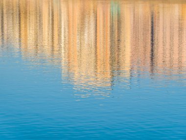 Soyut su yansıması resmi. Apartman binaları gölün sularına yansıyor..