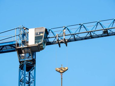 Ayrıntıları bir inşaat vincinin kabin kontrolüyle kapat. Turnayı mavi gökyüzüne doğru döndüren kule.