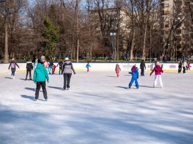 Bükreş, Romanya - 02.12.2021: Bükreş 'teki Cismigiu buz pateni pistinde kayan insanlar.