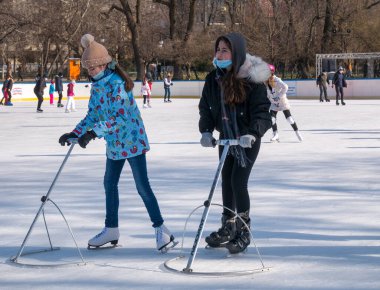 Bükreş, Romanya - 02.12.2021: Cismigiu paten pistinde buz pateni öğrenen genç kızlar