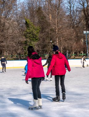 Bükreş 'teki Cismigiu buz pateni pistinde kayan insanlar.