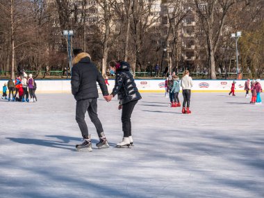 Bükreş, Romanya - 02.12.2021: Bükreş 'teki Cismigiu buz pateni pistinde kayan insanlar.
