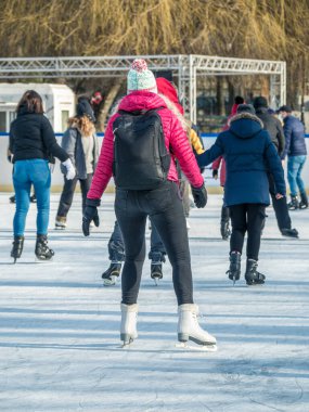 Bükreş 'teki Cismigiu buz pateni pistinde kayan insanların olduğu arka manzara.