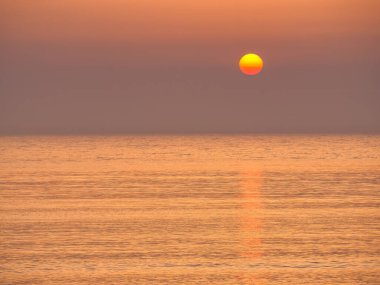 Beautiful sunrise or sunset over the calm water of the Black Sea. Beach summer landscape.