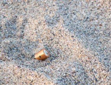 Improperly disposed batteries in the sand on the beach.Used waste batteries. Environmental pollution concept.