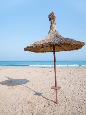 Summer landscape with straw umbrellas on the beach in Mangalia or Mamaia. Beach at the Black Sea in Romania.