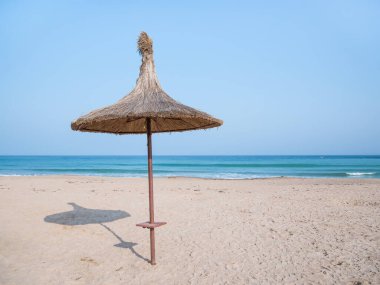 Summer landscape with straw umbrellas on the beach in Mangalia or Mamaia. Beach at the Black Sea in Romania.