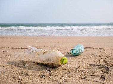 Plajda bırakılmış bir PET plastik şişe. Plastik kirliliği çevre kavramı.