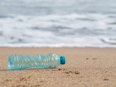 Plajda bırakılmış bir PET plastik şişe. Plastik kirliliği çevre kavramı.