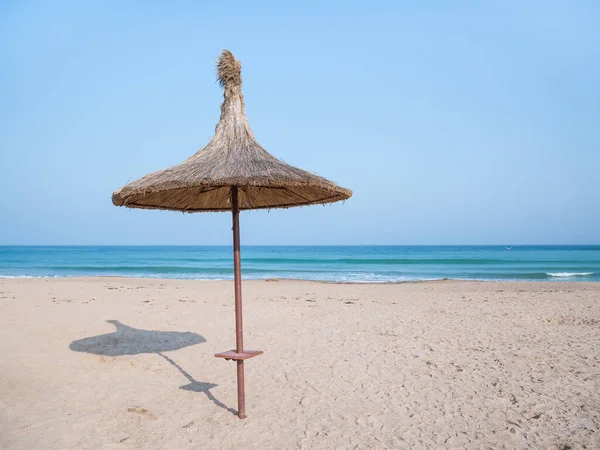Summer landscape with straw umbrellas on the beach in Mangalia or Mamaia. Beach at the Black Sea in Romania.