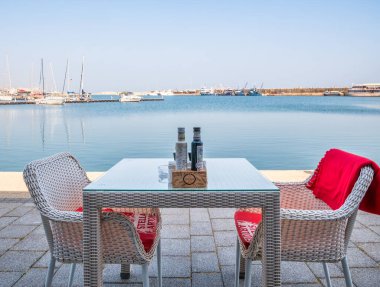 Köstence, Romanya - 02.25.2021: Köstence 'de Tomis Turistik Limanı' nda boş masa ve sandalyeler. Açık hava lokantası Cafe ve Terasse.