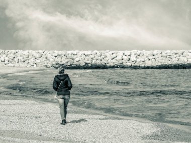 Romanya, Köstence 'de sahilde yürüyen yalnız bir kız.