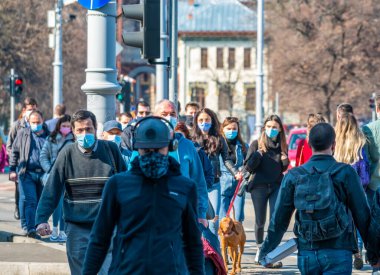 Bükreş, Romanya - 03.13.2021: Bükreş 'te elektrikli scooterlarla karşıdan karşıya geçen iki genç kız.