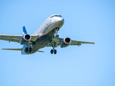 Otopeni, Romanya - 05.08.2021: Aeroflot Sukhoi Superjet 100-95B mavi gökyüzüne karşı uçuyor. Henry Coanda Uluslararası Havaalanına gelen uçak.