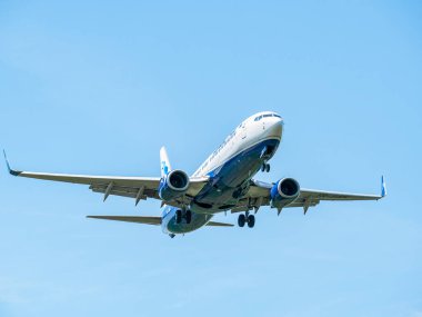 Otopeni, Romanya - 05.08.2021: Mavi Hava Boeing 737-82R (YR-BMK) mavi gökyüzüne karşı uçuyor. Henry Coanda Uluslararası Havaalanına gelen uçak.