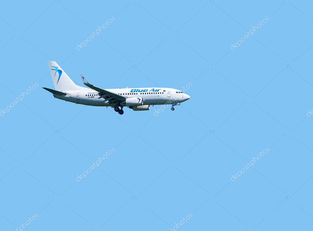 Otopeni, Romania - 05.08.2021: Blue Air Boeing 737-7K2 (YR-BMR) airplane flying against clear blue sky