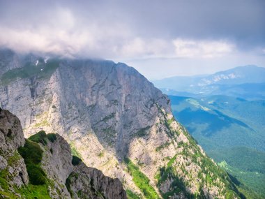 Kayalık dağlardaki fırtınalı bulutların arasından güneş ışığı. Romanya 'nın Bucegi Dağları' ndaki yaz manzarası