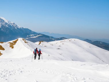 Karda yürüyen iki yürüyüşçü. Romanya 'nın Carapathian Dağları' ndaki kış manzarası.