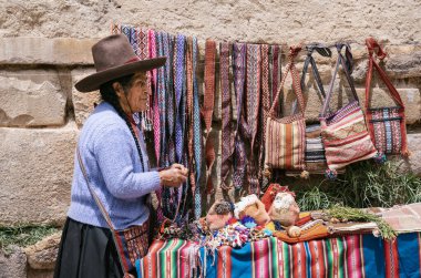 Ollantaytambo, Peru - 17 Mart 2025: Ollantaytambo Arkeoloji Sitesi 'nin girişinde geleneksel Peru hatıraları satan yaşlı kadın