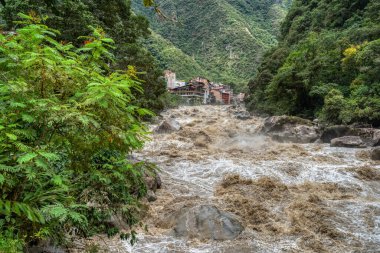 Urubamba Nehri 'nin güçlü sularının Aguas Calientes' teki kutsal vadiyi geçmesiyle dramatik bir manzara.